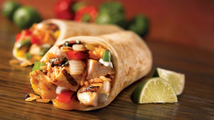 Chicken burrito with lime wedges